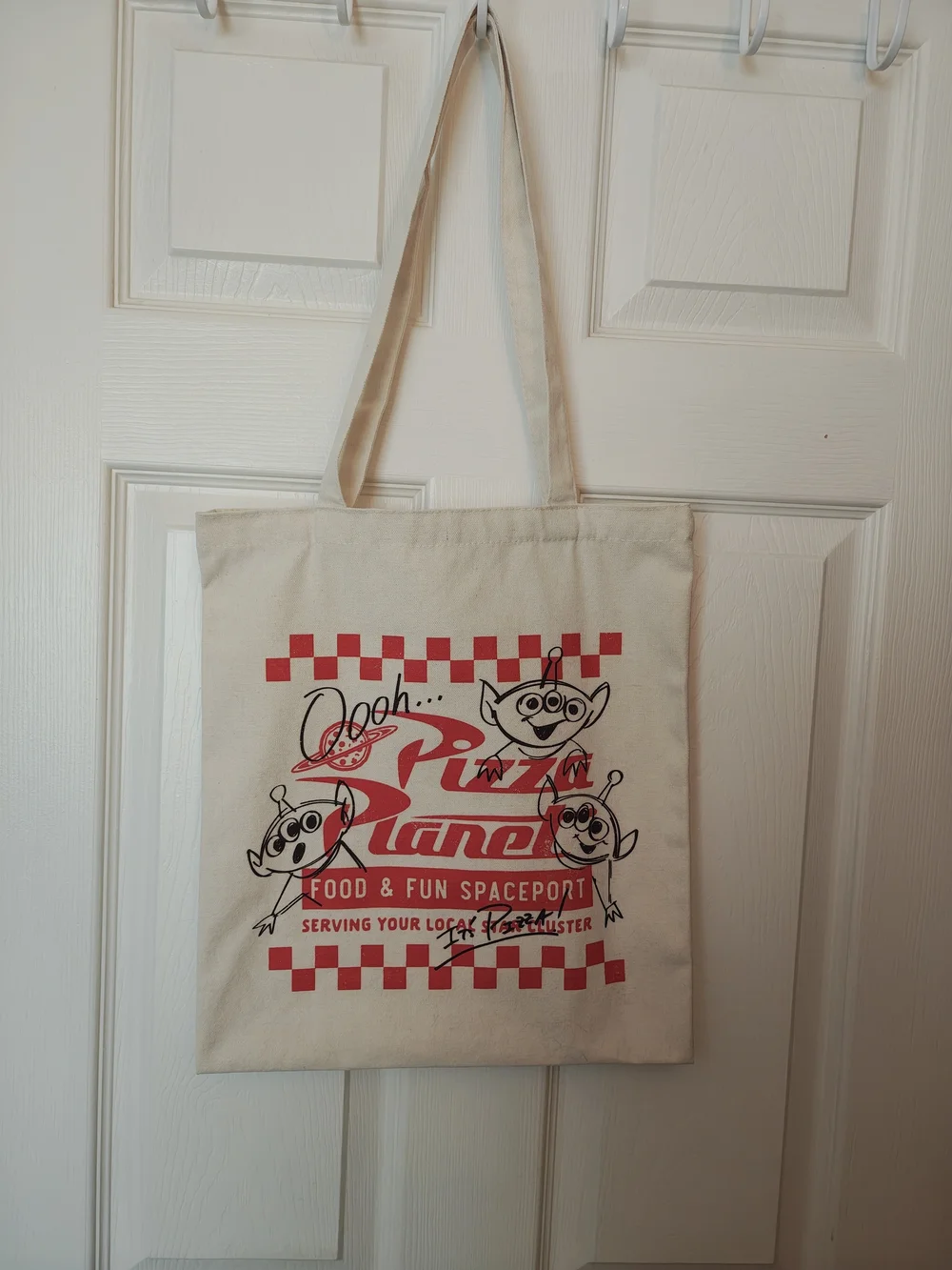 Pizza Planet Toy Story cream canvas tote bag.